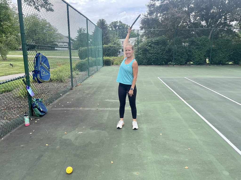 woman performing arm circles to warm up for pickleball