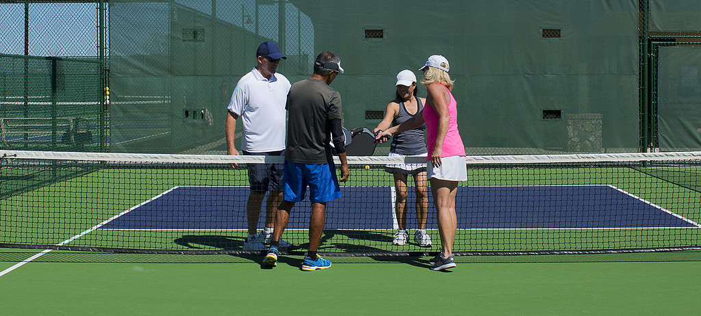 four pickleball players showing sportsmanship